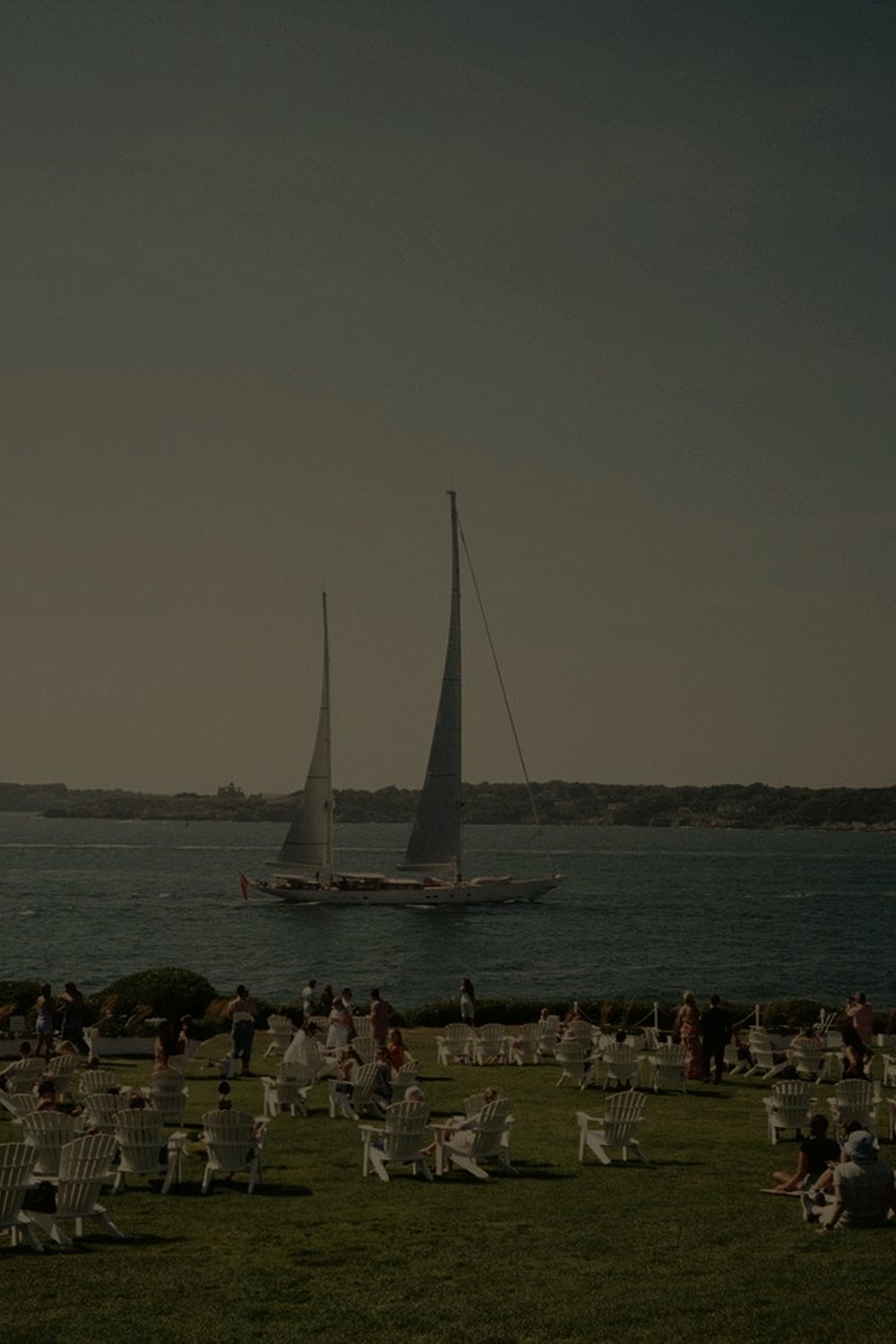 Adirondack chairs on the lawn, a sailboat offshore